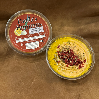 An open container of Paula's Hummus Sundried Tomato and Oregano